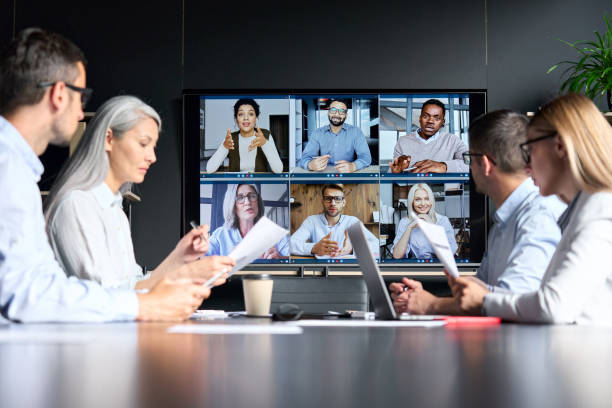 global corporation online videoconference in meeting room with diverse people sitting in 1